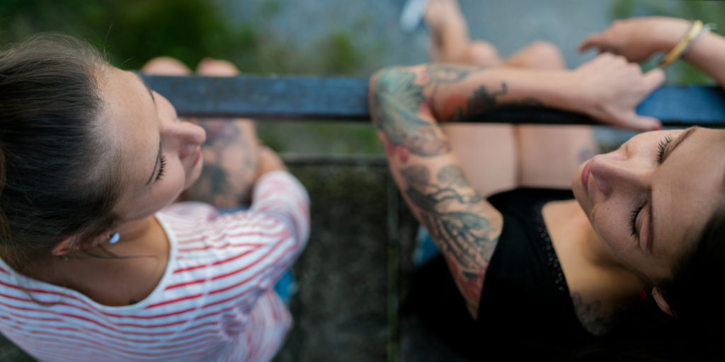 zwei Frauen sitzen auf einer Brücke