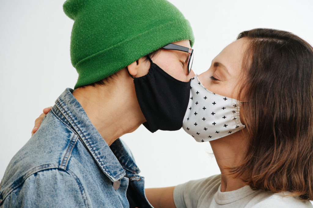 Zwei Menschen mit Maske küssen sich