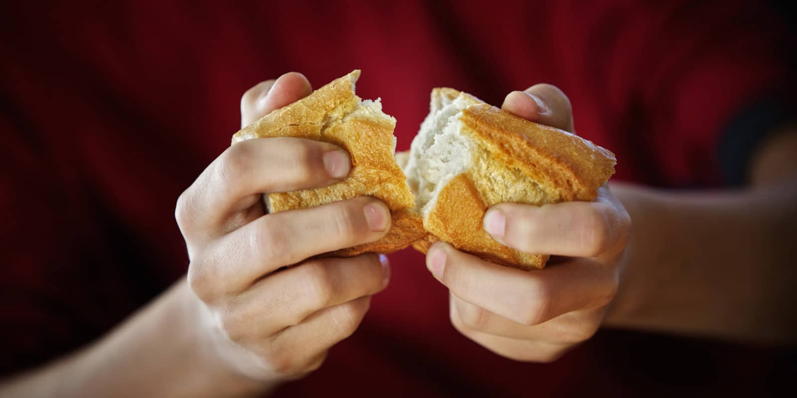 zwei Hände brechen Baguette