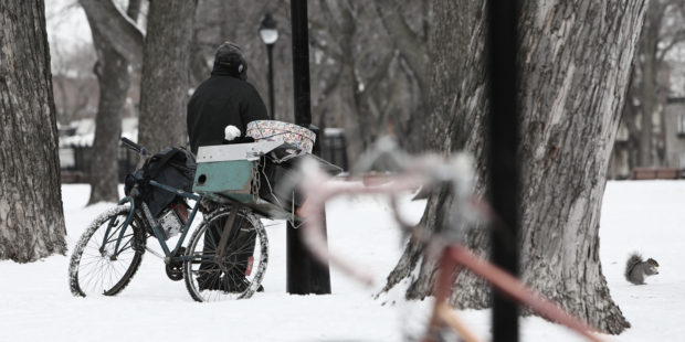 Obdachloser mit Fahrrad in Winterlandschaft