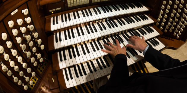Mann spielt auf einer Orgel
