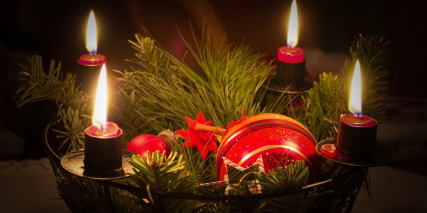 Adventskranz mit vier leuchtenden Kerzen