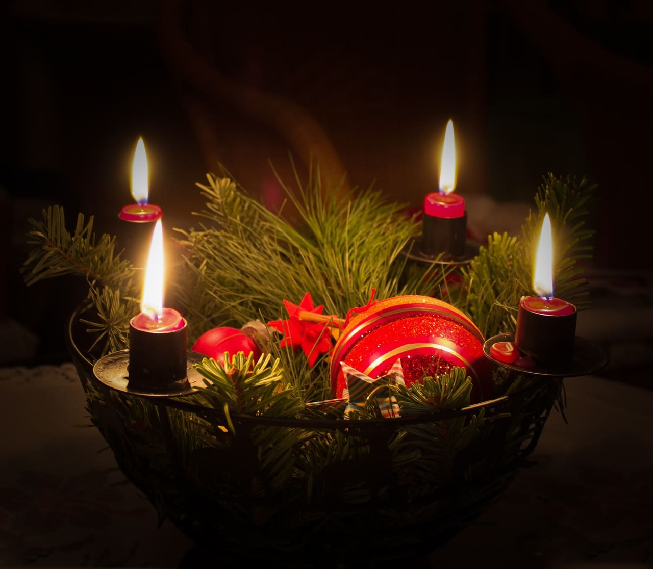 Adventskranz mit vier leuchtenden Kerzen