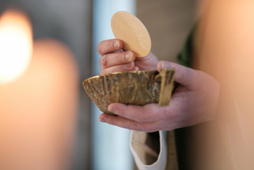 Hände, die Brot über einer Schale halten