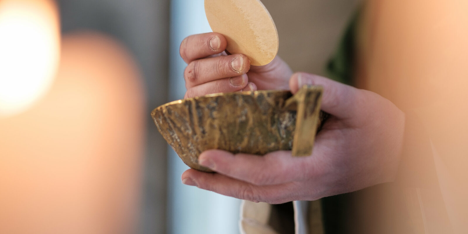 Hände, die Brot über einer Schale halten