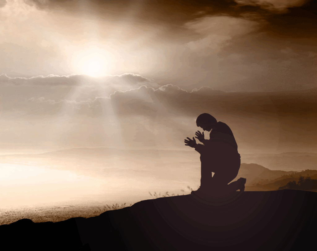 Silhouette einer knienden Person auf einem Hügel