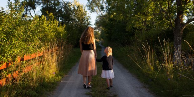 Mutter mit Tochter gehen einen Weg entlang