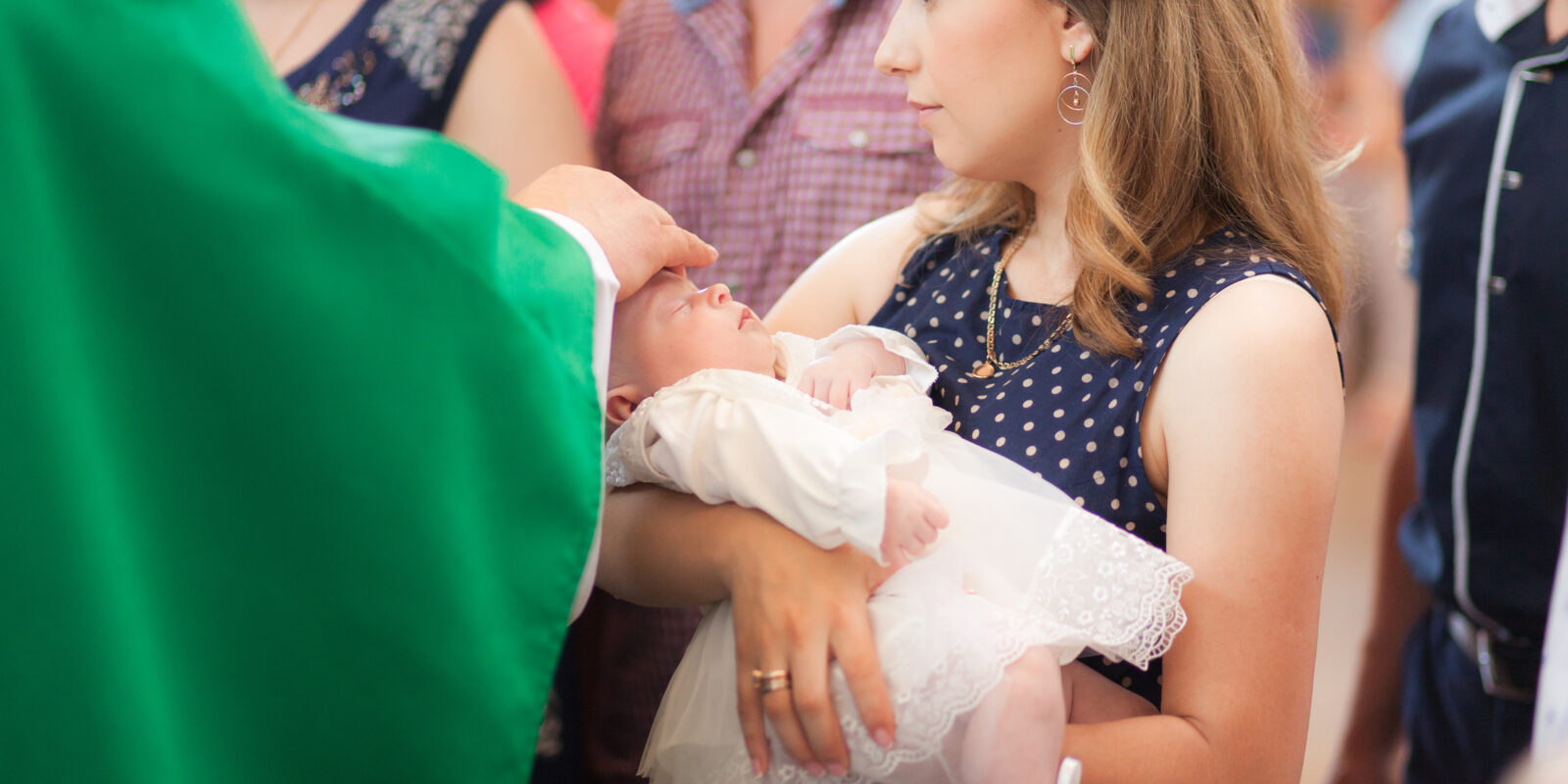 Frau mit Baby in der Kirche bei der Taufe