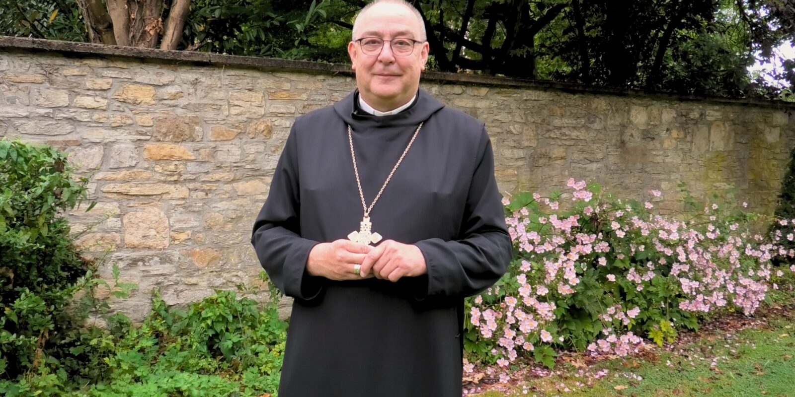 Bischof Dominicus in seinem Garten vor einer Mauer