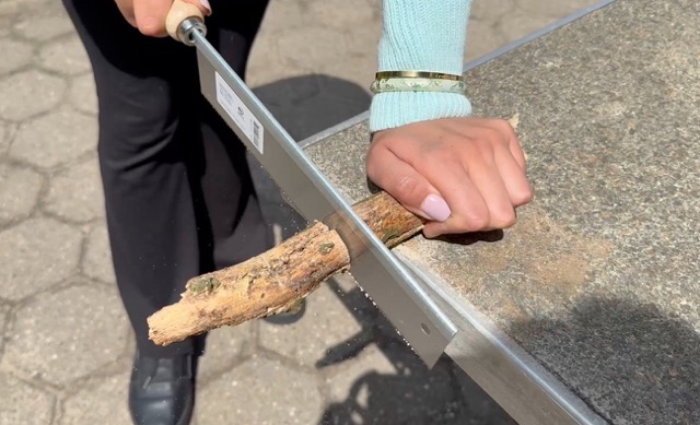 Zwei Hände sägen Holz