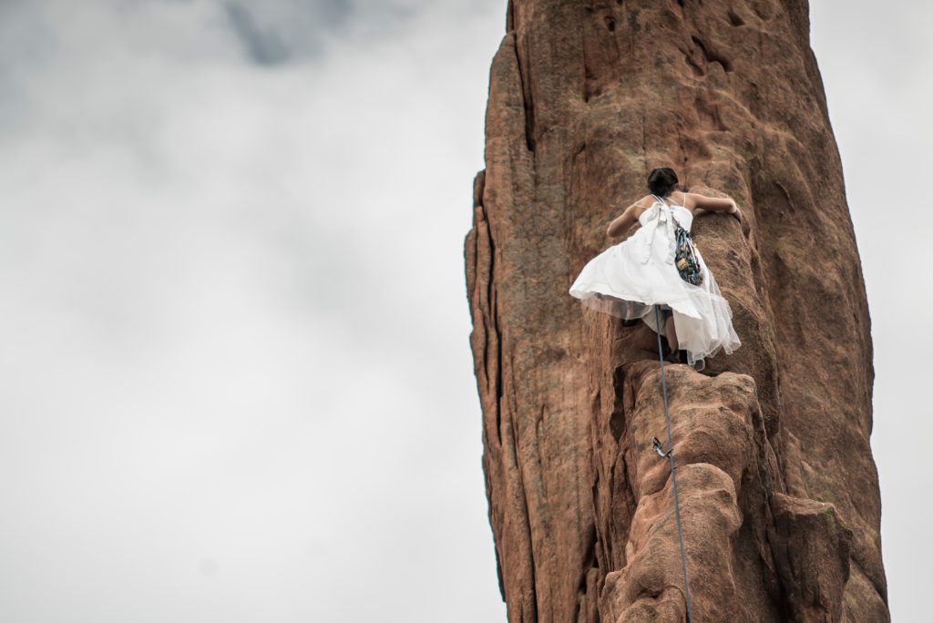 Braut klettert Felswand hoch