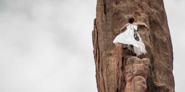 Braut klettert Felswand hoch