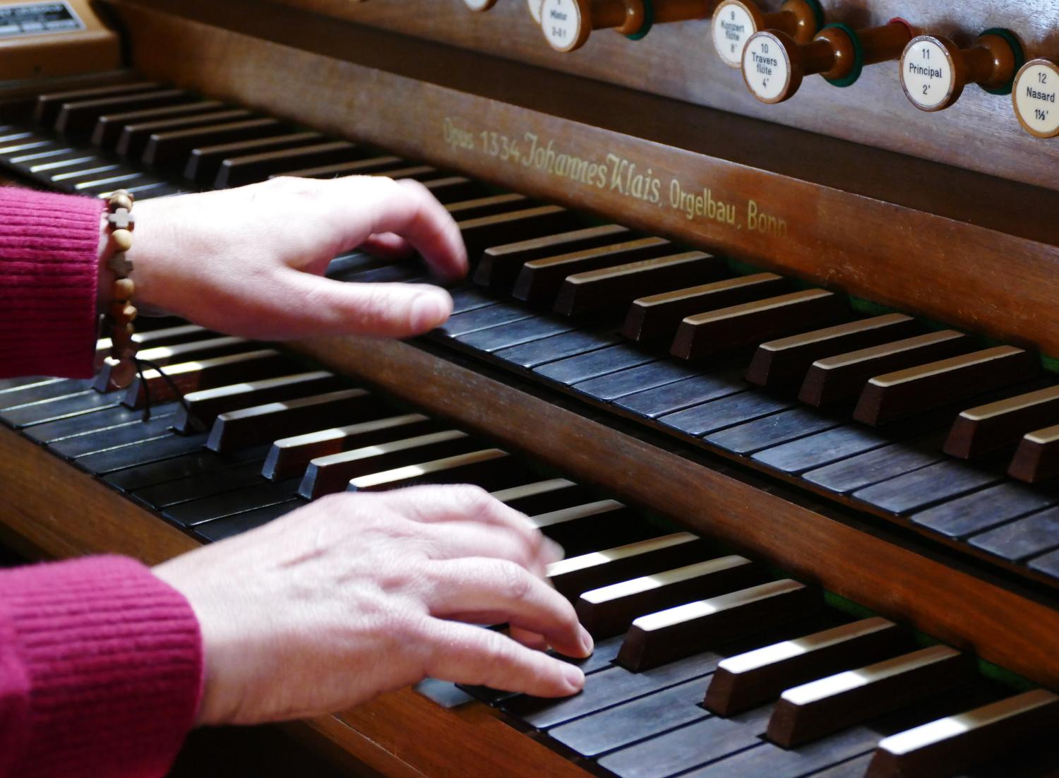 Hände spielen auf einer Orgel