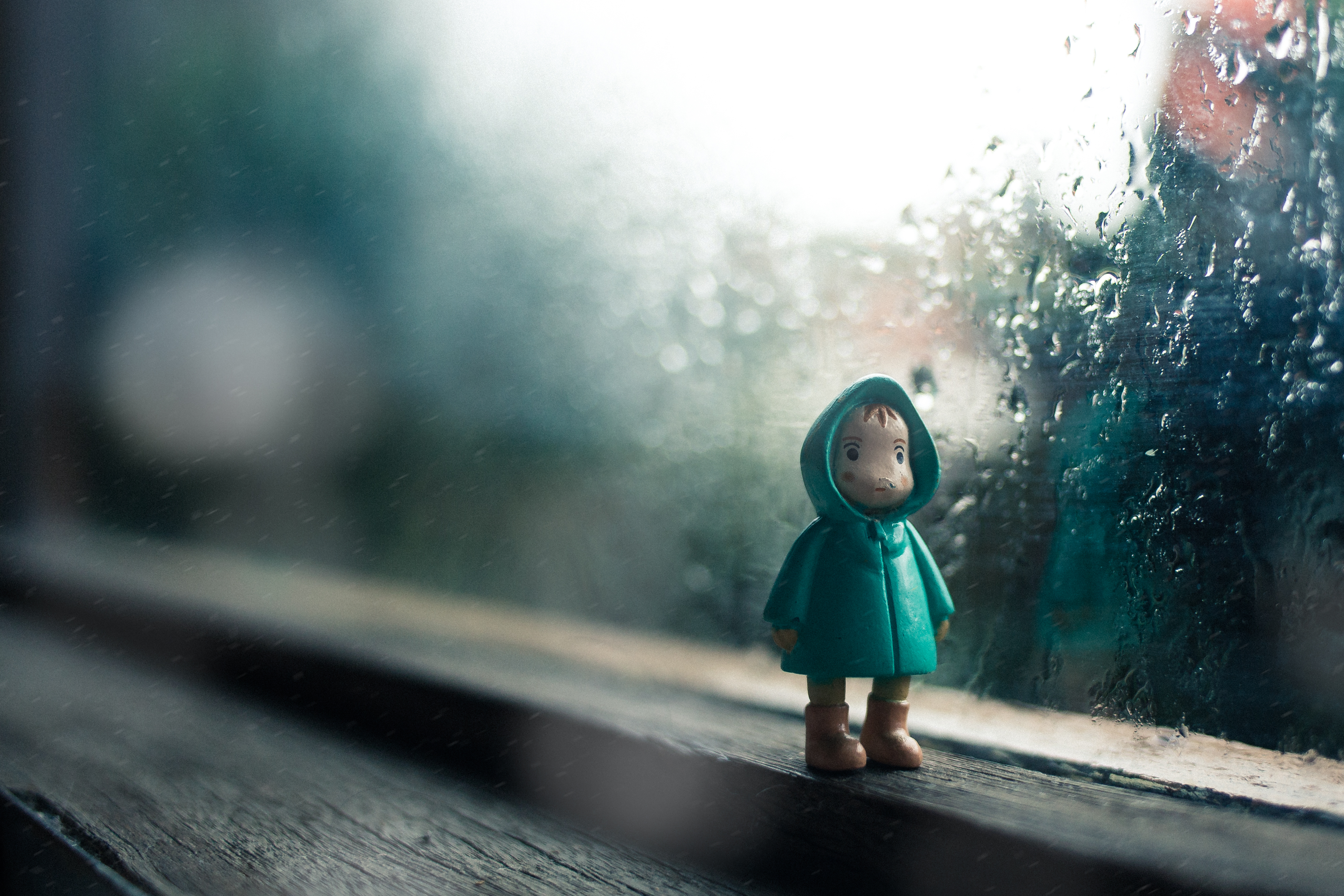 Holzfigur am Fenster, Regenwetter