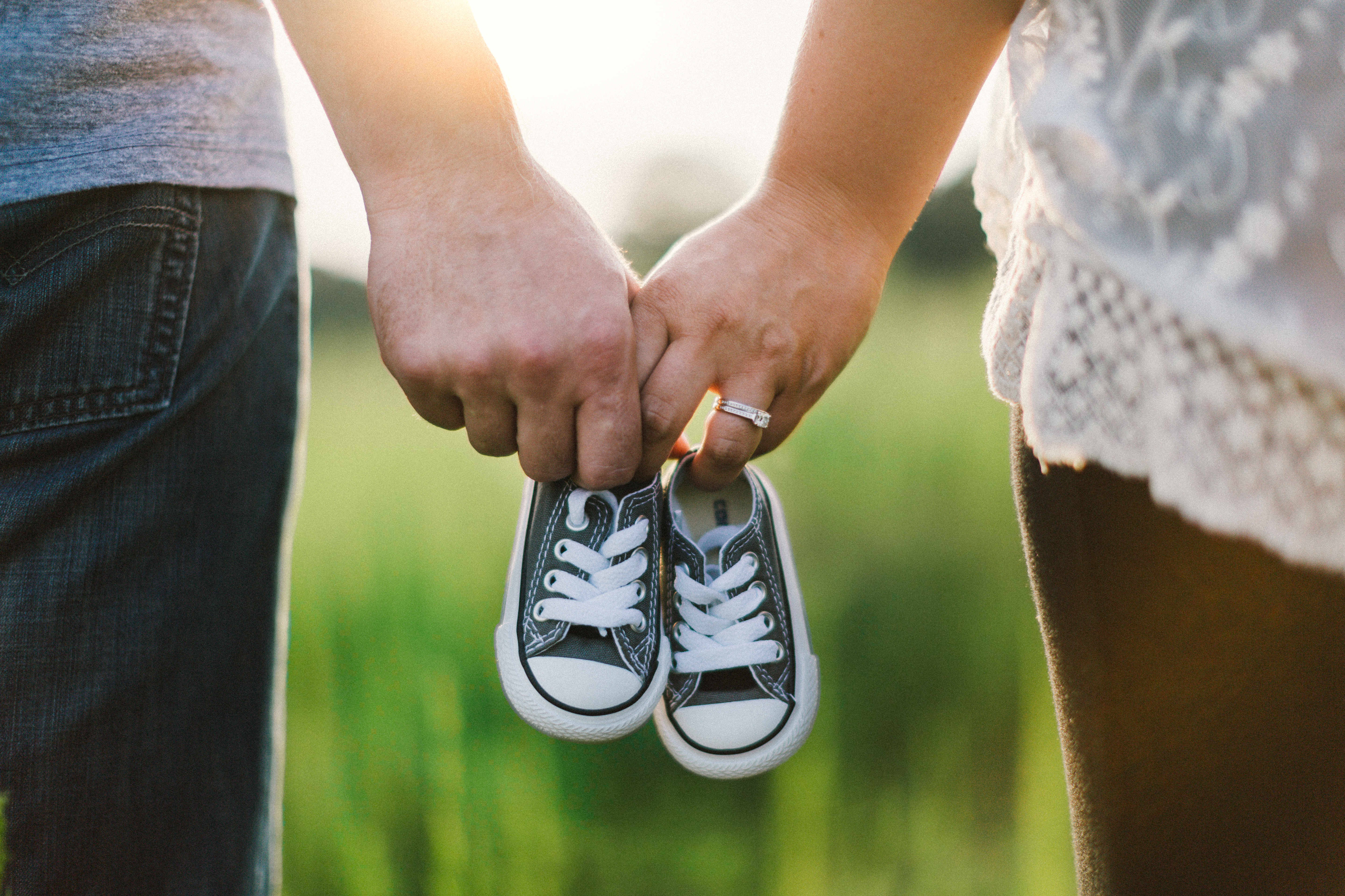 Ein Paar hält Babyschuhe