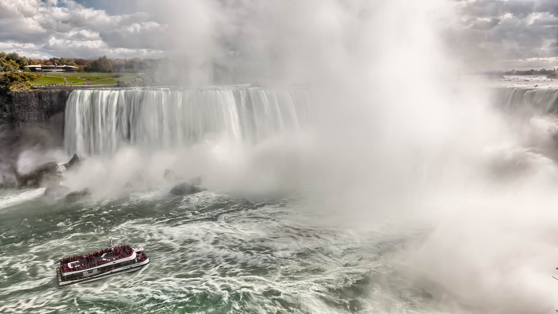 Ein Boot nähert sich einem Wasserfall.