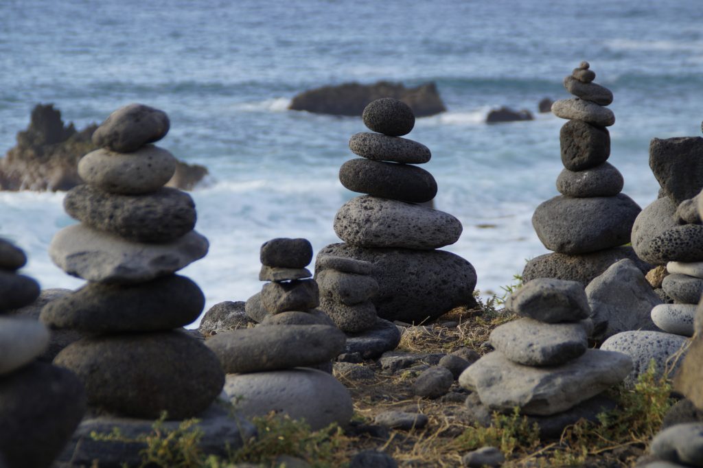 Einige Steine sind am Meer übereinander gestapelt.