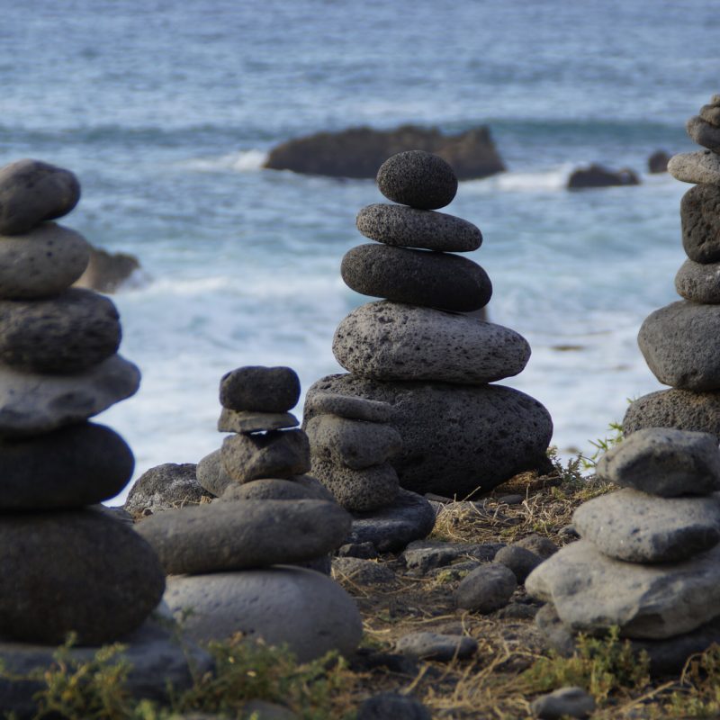 Einige Steine sind am Meer übereinander gestapelt.