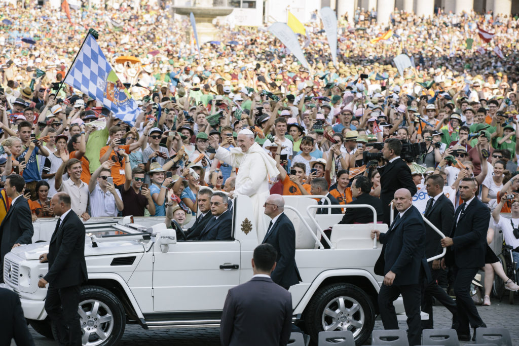 Papst Franziskus fährt mit dem Papamobil durch die Menge der Ministranten.