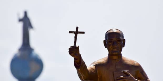 Eine Statue von Oscar Romero, der ein Kreuz hält, steht bei dessen Seligsprechung am 23. Mai 2015 in San Salvador vor dem Denkmal Monumento al Divino Salvador del Mundo, dem Wahrzeichen von El Salvador.