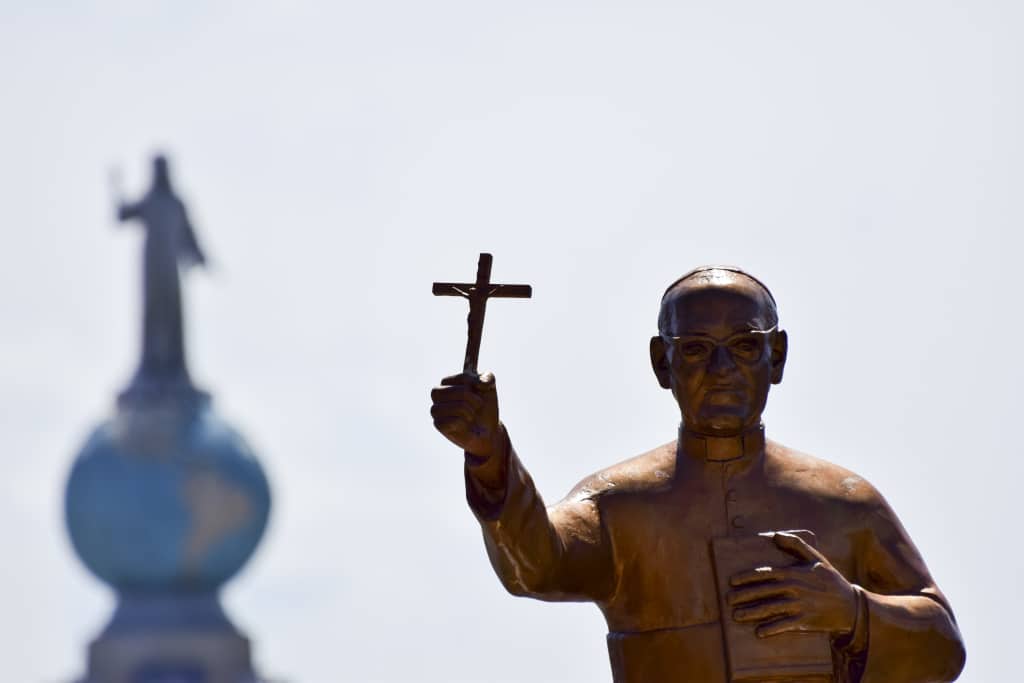 Eine Statue von Oscar Romero, der ein Kreuz hält, steht bei dessen Seligsprechung am 23. Mai 2015 in San Salvador vor dem Denkmal Monumento al Divino Salvador del Mundo, dem Wahrzeichen von El Salvador.