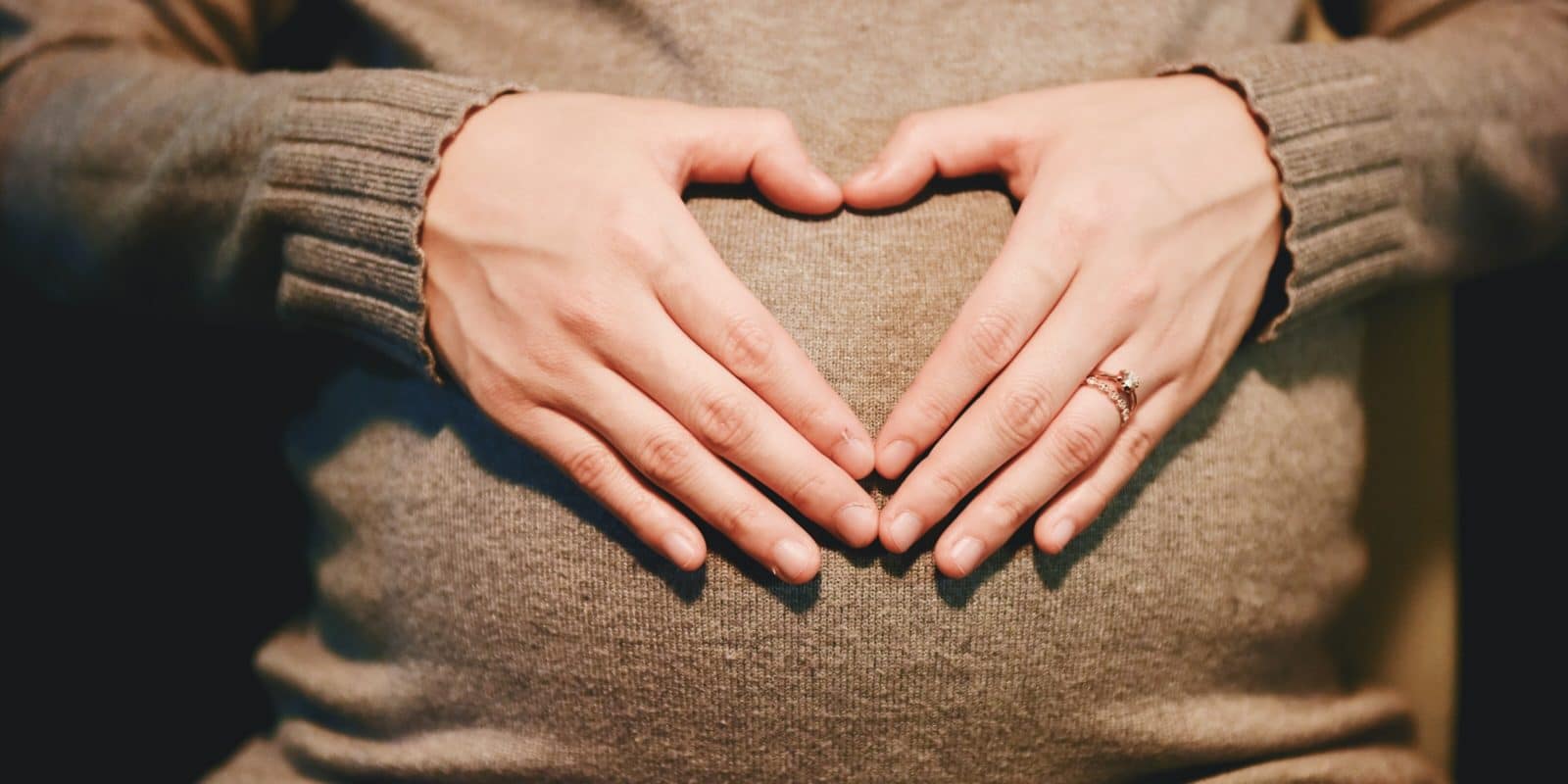 Hände auf einem Babybauch