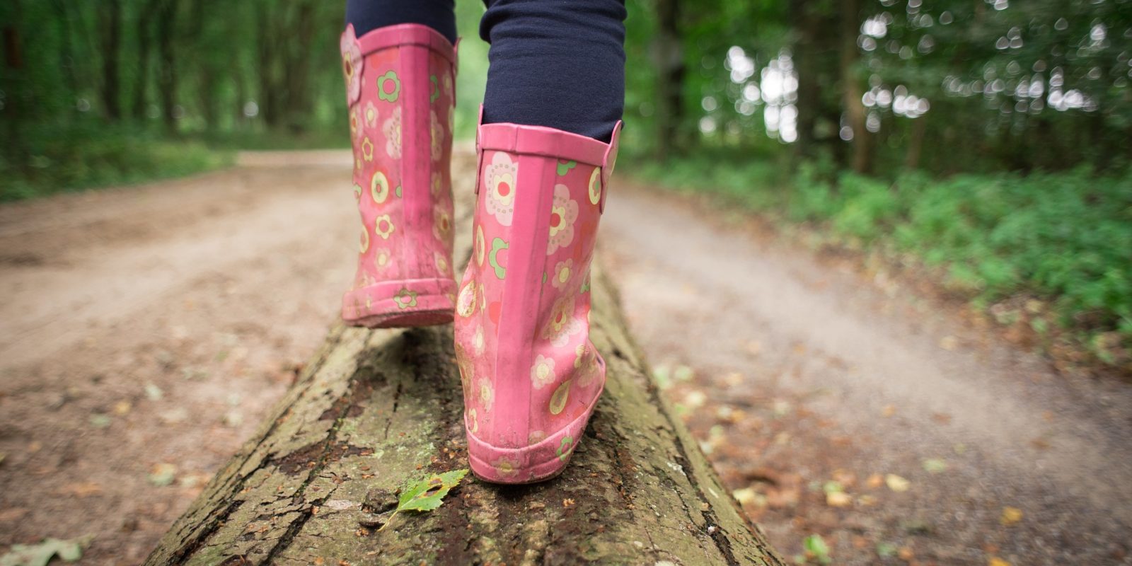 Kinderstiefel balancieren auf Baumstamm