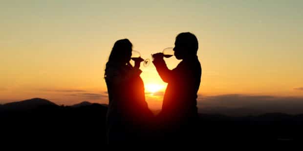 Ein Paar trinkt Wein vor einem Sonnenuntergang