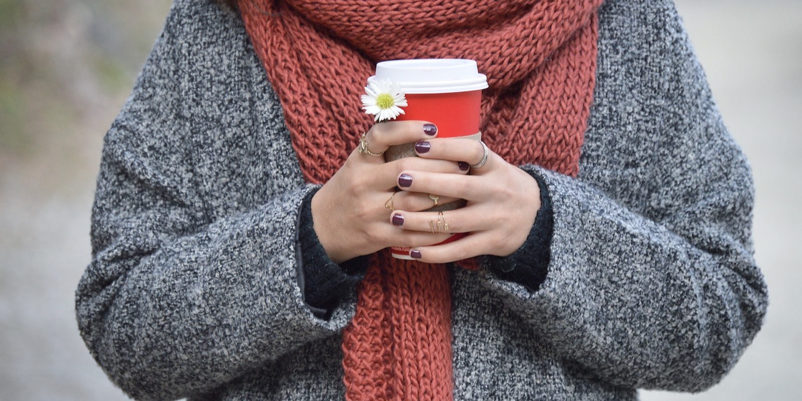 Frau hält Kaffeebecher