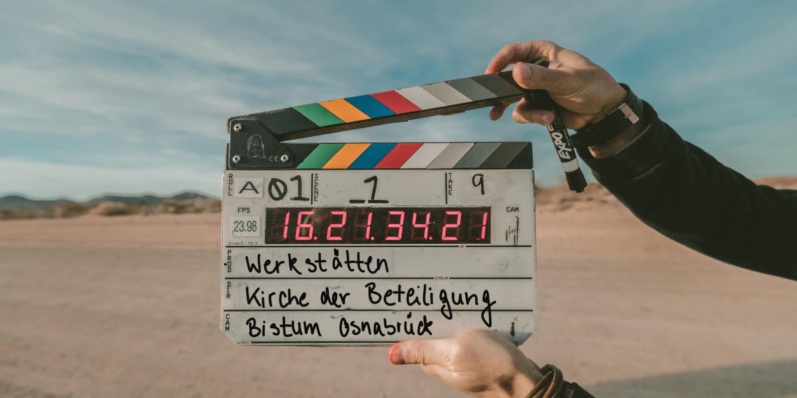 Filmklappe wird von zwei Händen gehalten