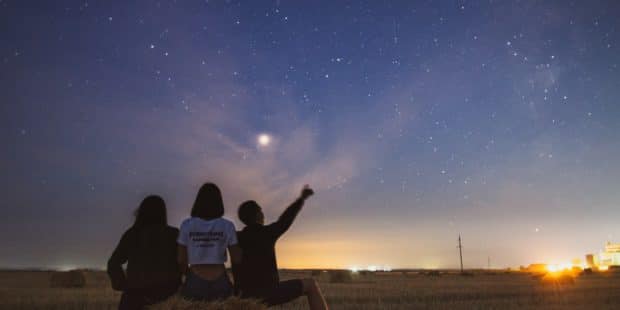 Drei Personen bewundern Sternenhimmel