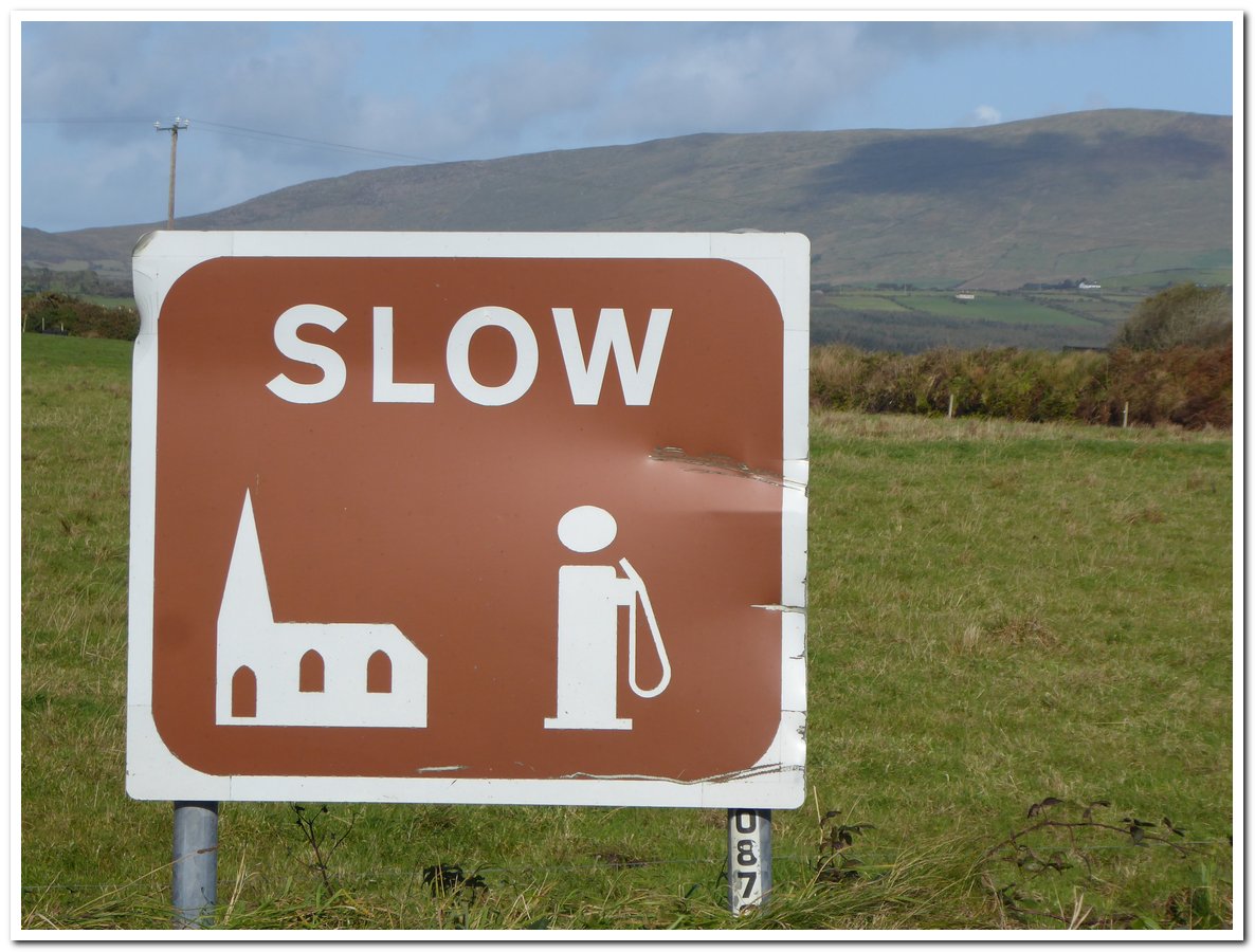 Schild mit Kirche und Tankstelle