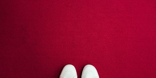 Schuhspitzen auf einem roten Teppich