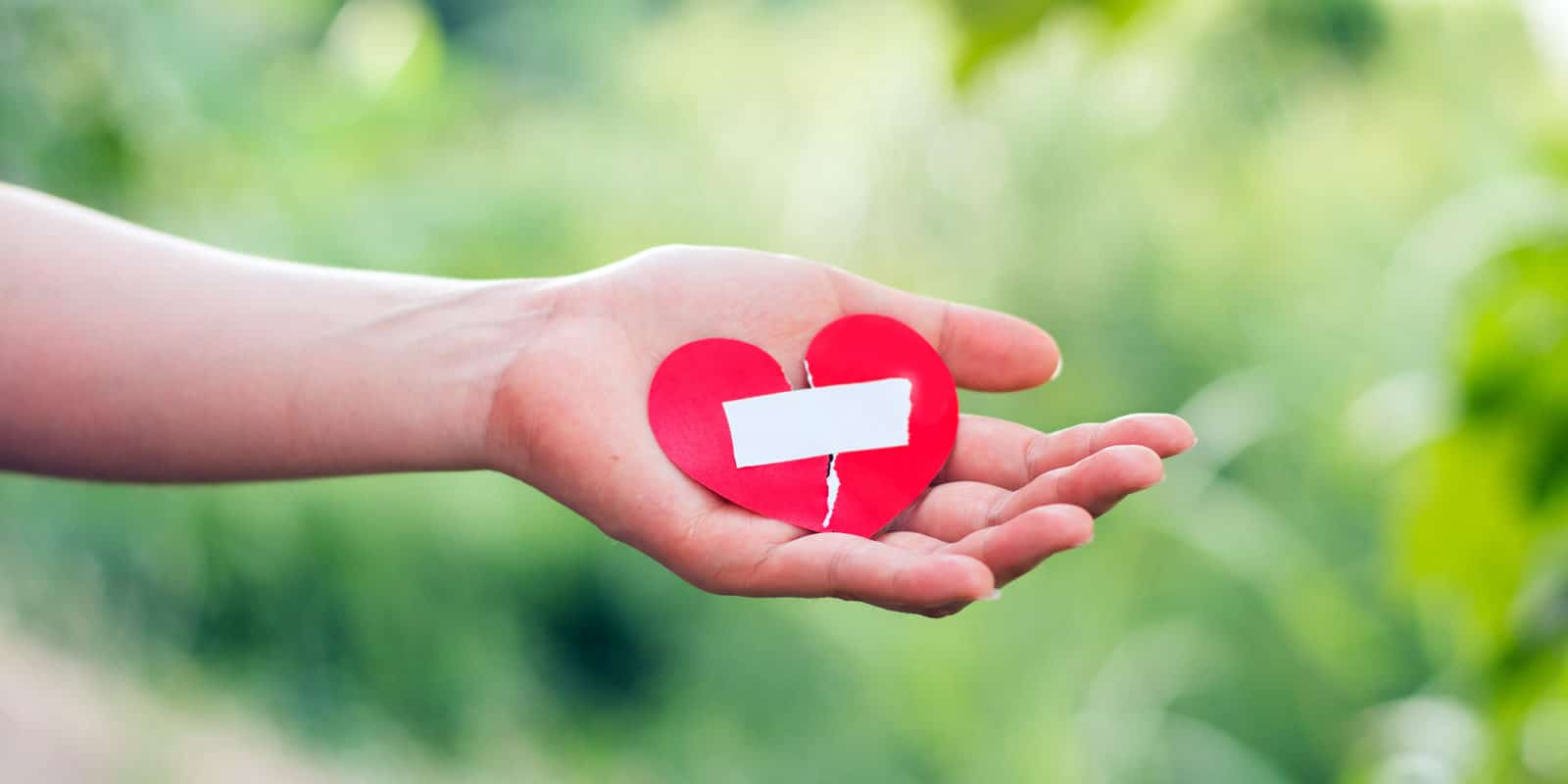 Frau hält geklebtes Herz in der Hand