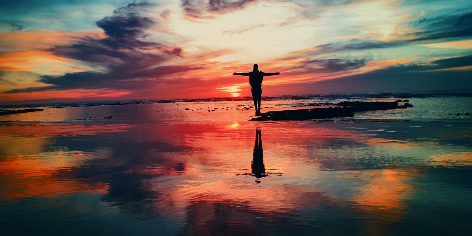 Mensch am Strand bei Sonnenaufgang