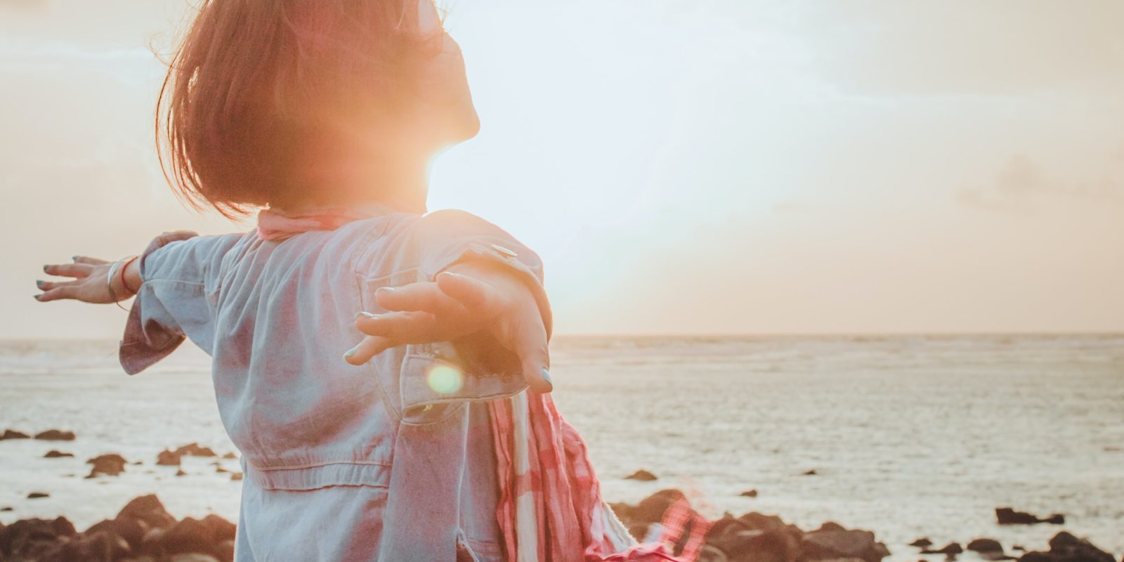 Frau steht am Meer