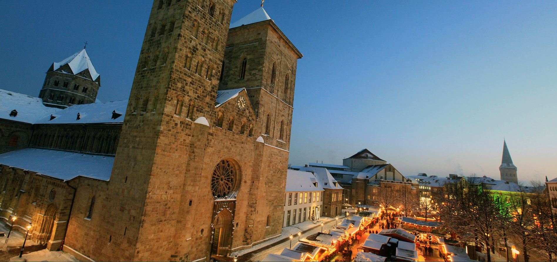 Der Osnabrücker Dom mit dem Weihnachtsmarkt im Vordergrund.