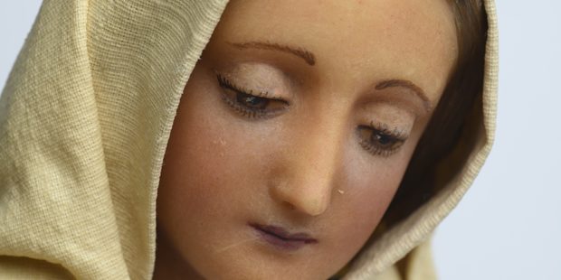 Eine Marienfigur: Maria schaut nach unten, sie trägt ein weißes Gewand. ,