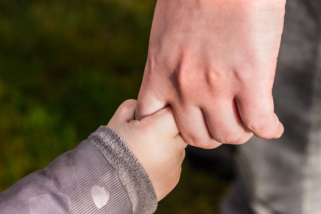 Eine Kinderhand hält eine Erwachsenenhand