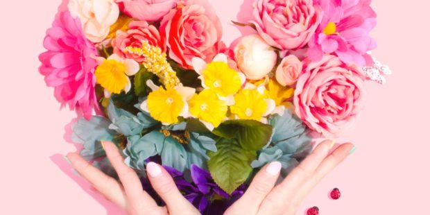 Hände halten bunten Blumenstrauß