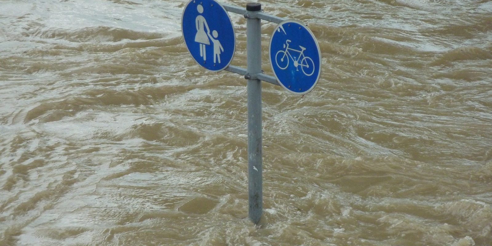 Straßenschild im Hochwasser