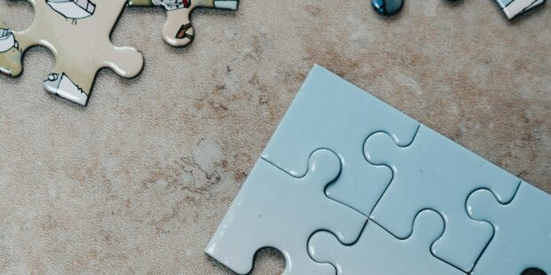 white jigsaw puzzle pieces on brown marble table