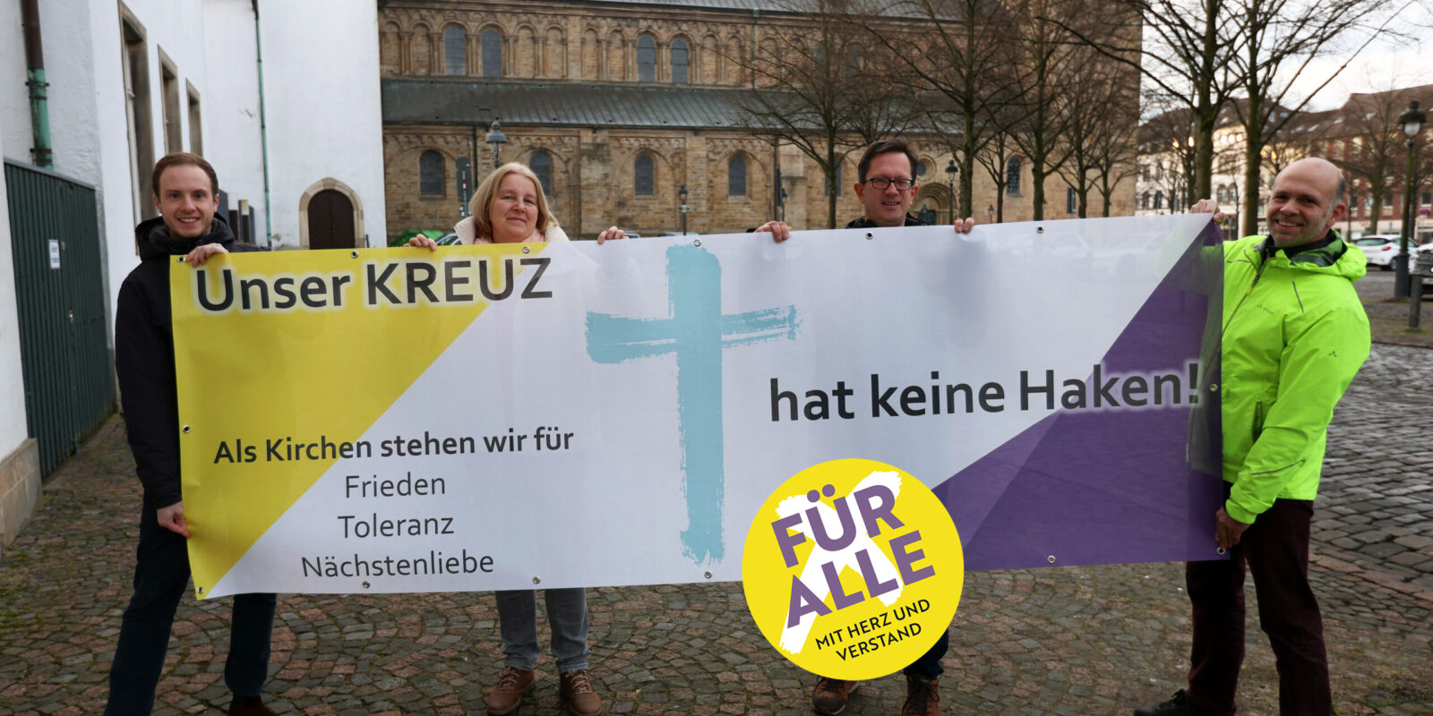 „Unser Kreuz hat keine Haken“ – das Banner der Aktion wird ab dem 27. Januar an Kirchen und kirchlichen Gebäuden in Osnabrück und der umliegenden Region hängen. Auf dem Foto (von links) Cedrik Fritz, Marita Moro, Frank Hemme-Pelzer von der katholischen Domgemeinde St. Petrus in Osnabrück und Friedemann Keller von der evangelischen Kirchengemeinde St. Michaelis.