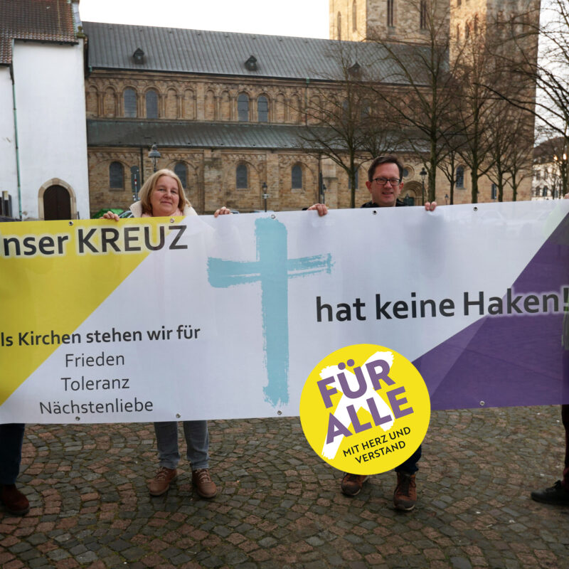 „Unser Kreuz hat keine Haken“ – das Banner der Aktion wird ab dem 27. Januar an Kirchen und kirchlichen Gebäuden in Osnabrück und der umliegenden Region hängen. Auf dem Foto (von links) Cedrik Fritz, Marita Moro, Frank Hemme-Pelzer von der katholischen Domgemeinde St. Petrus in Osnabrück und Friedemann Keller von der evangelischen Kirchengemeinde St. Michaelis.