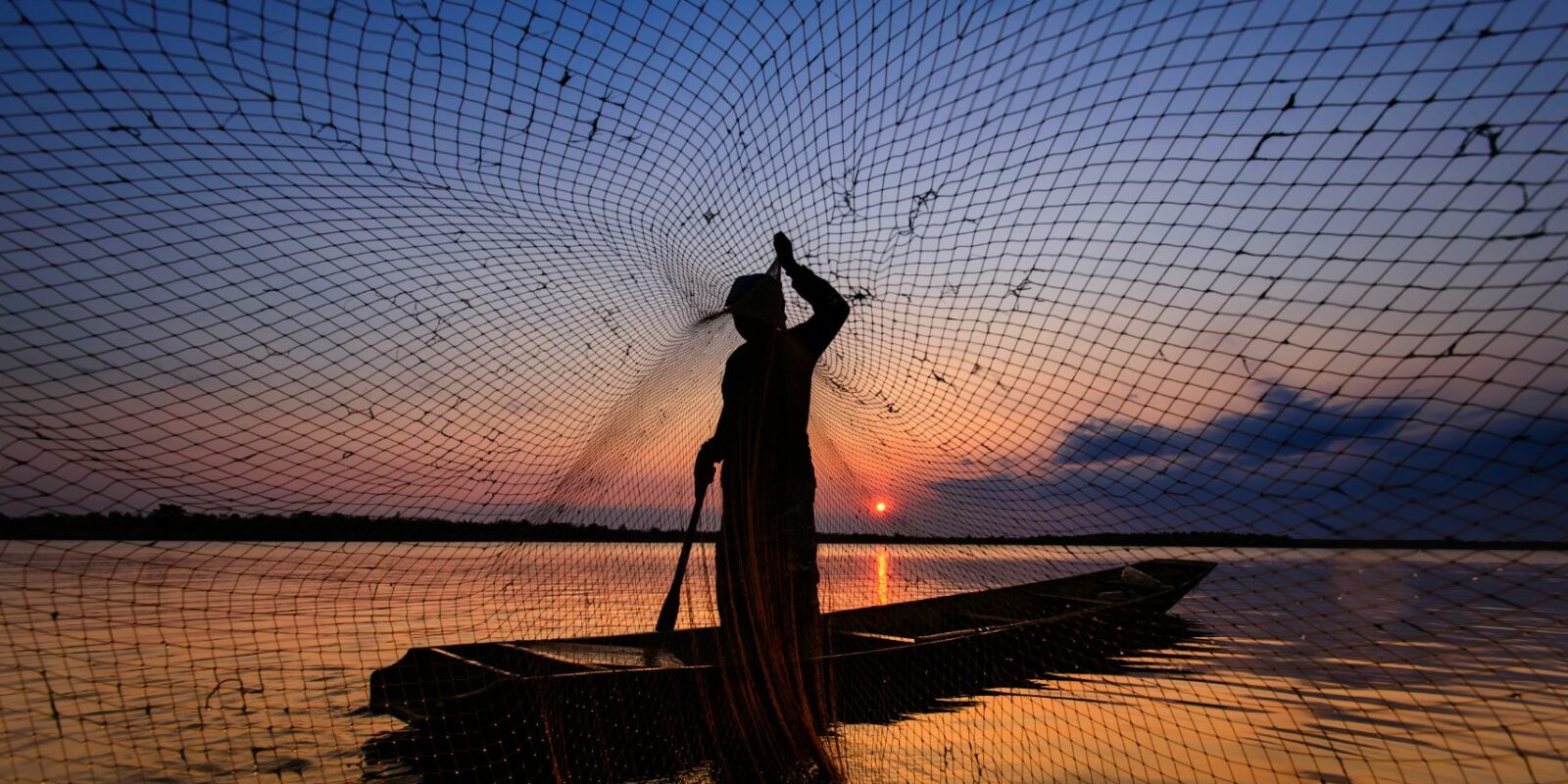 Boots im Sonnenuntergang mit Fischernetz