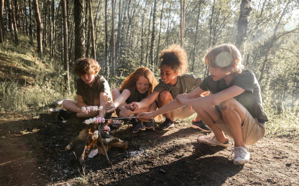 Kinder mit Stöckern am Lagerfeuer
