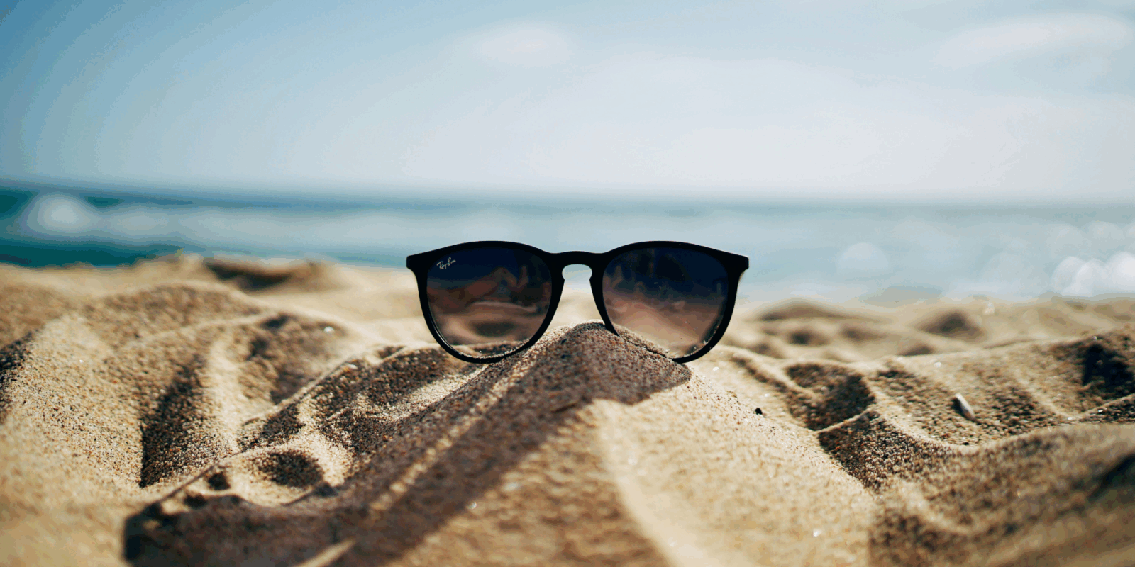 Eine Sonnenbrille im Sand