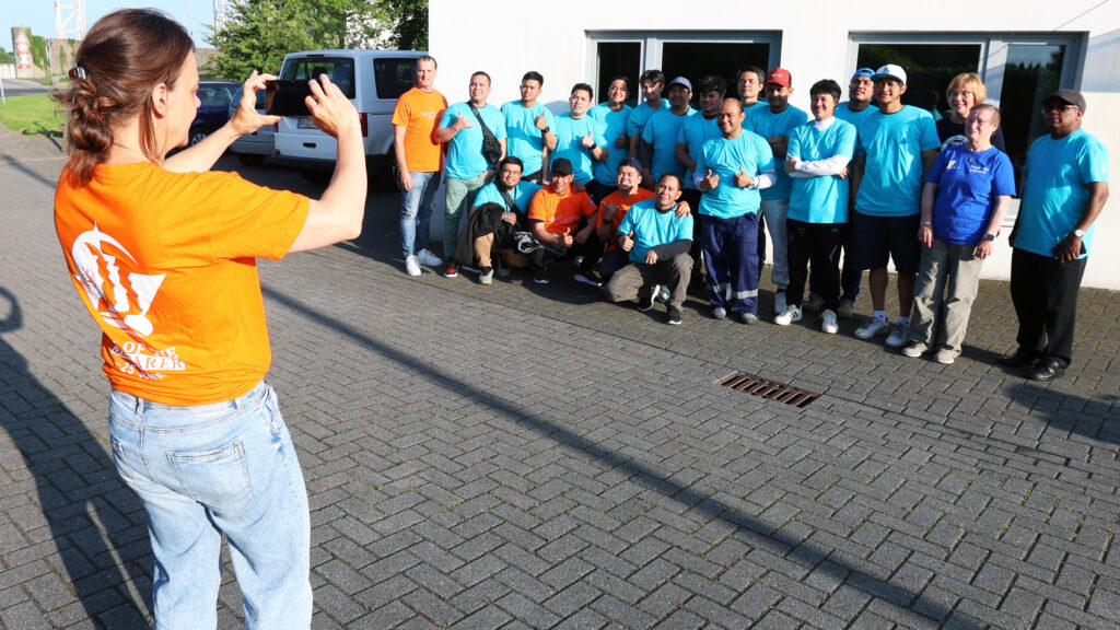 Christine Freytag fotografiert die Gruppe der Seemänner, die zum Tag der Seeleute in den Club gekommen sind.