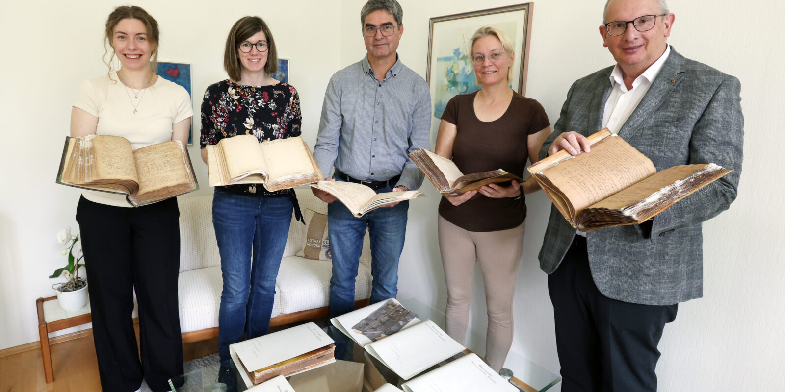 Präsentieren die restaurierten Bände aus dem Pfarrarchiv St. Johann: (von links) Lena Witteborg (Auszubildende im Bistumsarchiv), Janine Wasmuth (Praktikantin), Georg Wilhelm (Archivar), Dagmar Dornheim (Restauratorin) und Martin Schomaker (Dechant und Pfarrer von St. Johann).