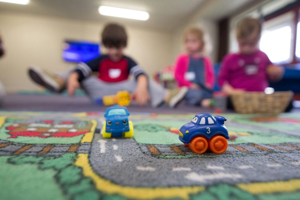 Kinder spielen auf einem Autoteppich